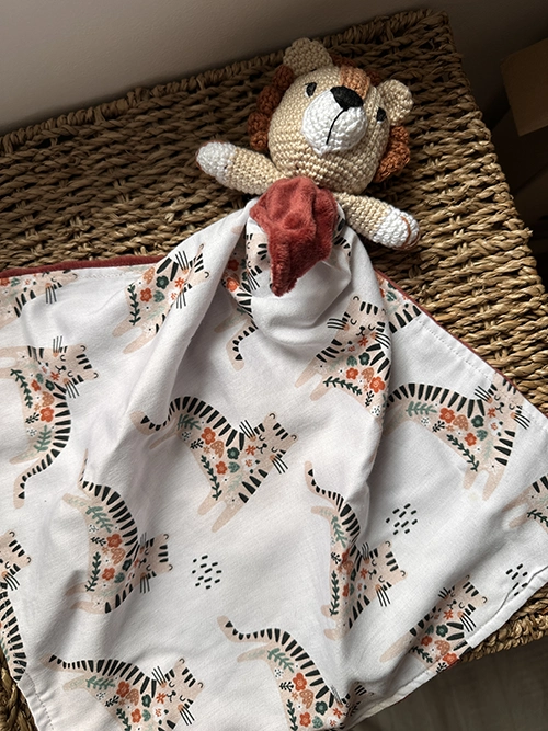 Doudou plat lion au crochet aux couleurs crème et terracotta, avec tissu imprimé lion et verso en polaire Minky ultra douce pour bébé. 🦁🧡