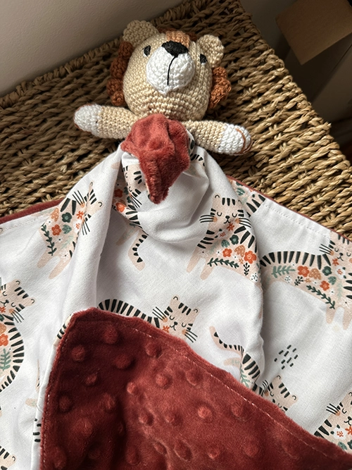 Doudou plat lion au crochet aux couleurs crème et terracotta, avec tissu imprimé lion et verso en polaire Minky ultra douce pour bébé. 🦁🧡
