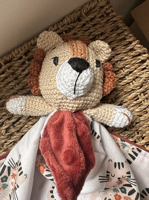 Doudou plat lion au crochet aux couleurs crème et terracotta, avec tissu imprimé lion et verso en polaire Minky ultra douce pour bébé. 🦁🧡