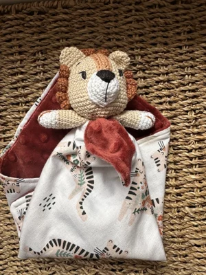 Doudou plat lion au crochet aux couleurs crème et terracotta, avec tissu imprimé lion et verso en polaire Minky ultra douce pour bébé. 🦁🧡