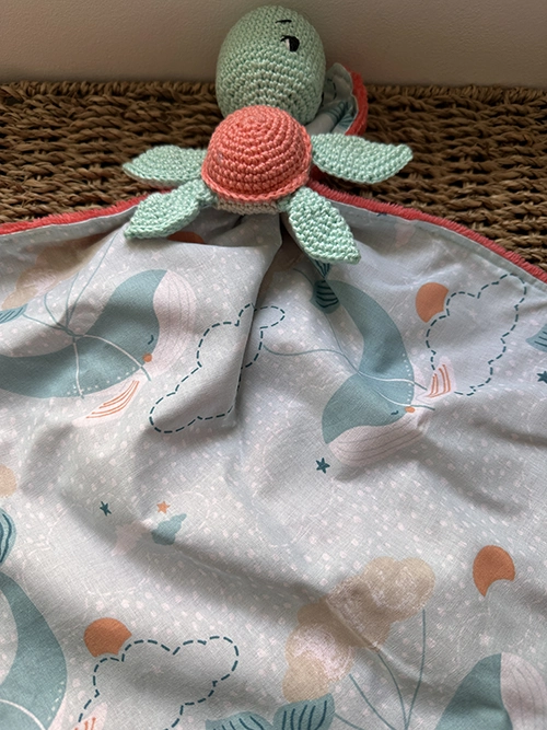 Doudou plat tortue au crochet vert d'eau et corail avec tissu imprimé pastel et tissu Minky ultra doux pour bébé.