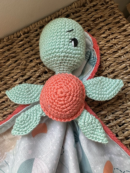 Doudou plat tortue au crochet vert d'eau et corail avec tissu imprimé pastel et tissu Minky ultra doux pour bébé.